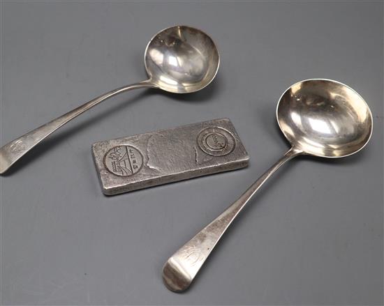 A pair of George III silver sauce ladles and a Chinese 0.999 white metal ingot.